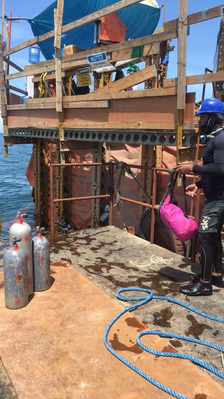 Dive platform with scuba tanks and equipment, diver prepping