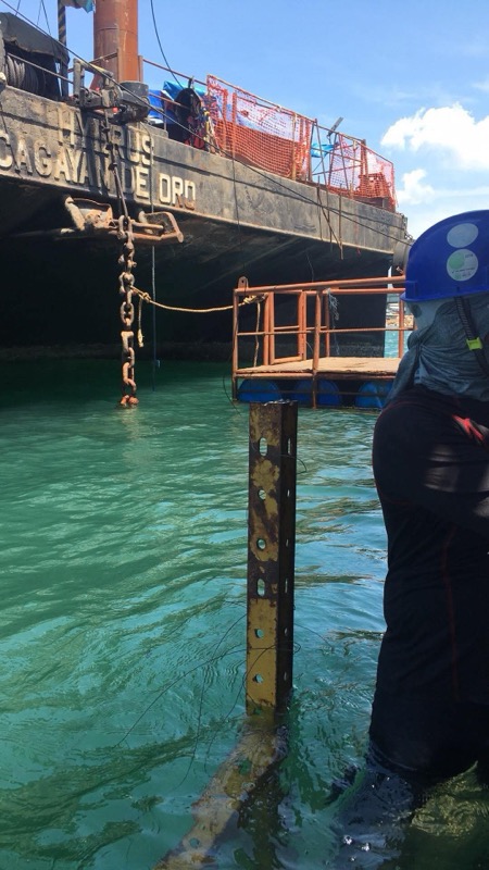 Diver at piling with vessel during underwater inspection