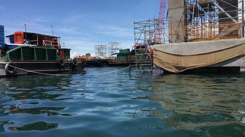 Water-level shot of port infrastructure with boats and scaffolding
